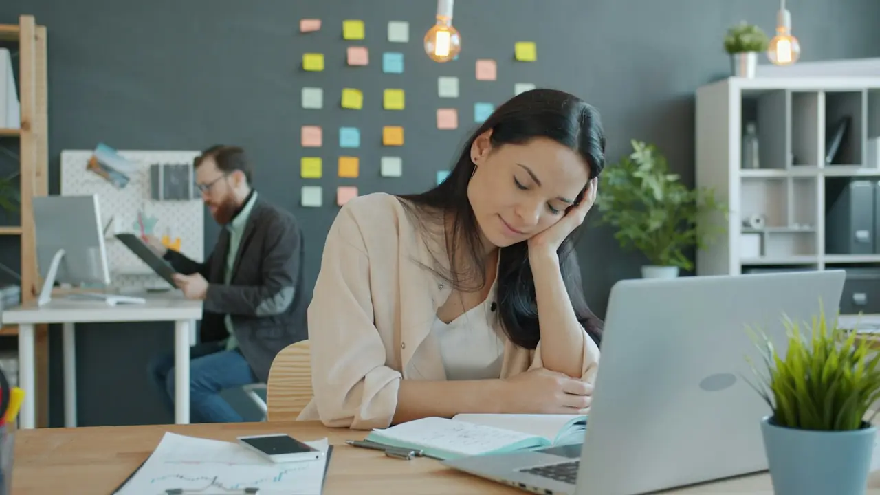 Vermoeide vrouw aan haar bureau op kantoor