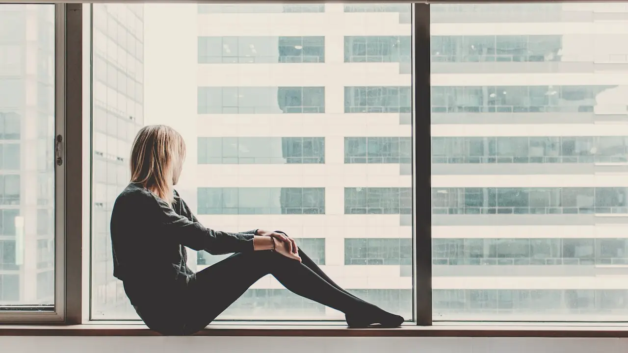 Jonge vrouw bij een groot raam
