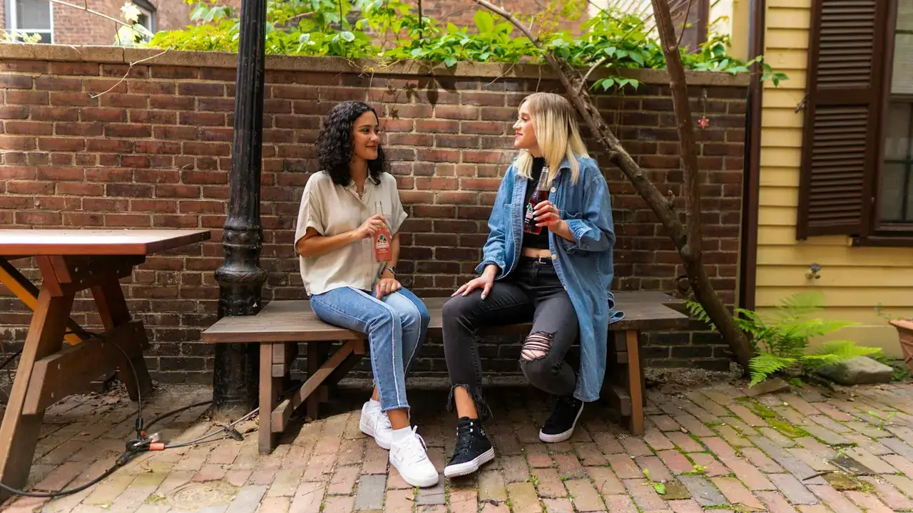 Twee vrouwen in gesprek op een bankje buiten