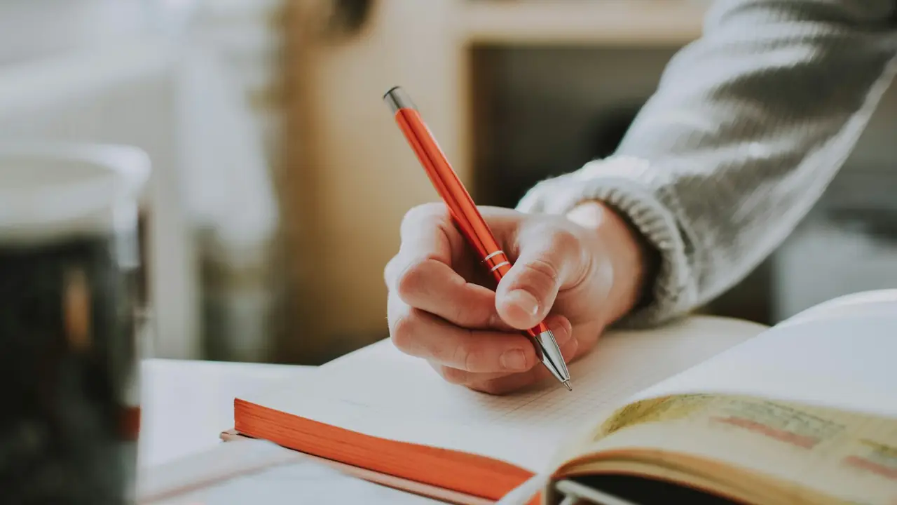 Hand die schrijft in een dagboek