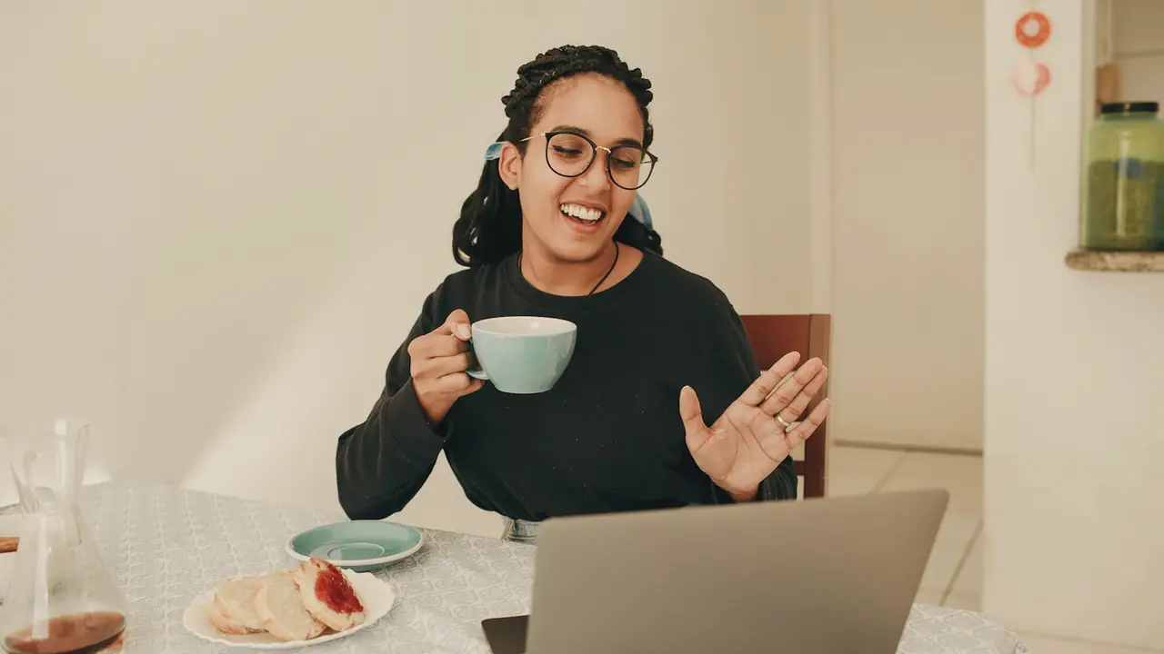 Vrouw in een videogesprek aan tafel
