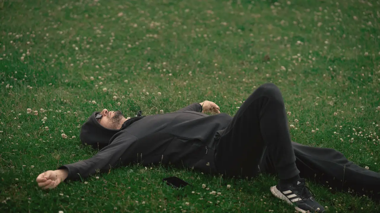 Man die ontspannen in het gras ligt