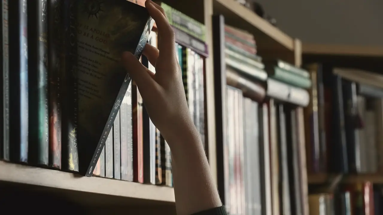 Hand die een boek uit de kast pakt