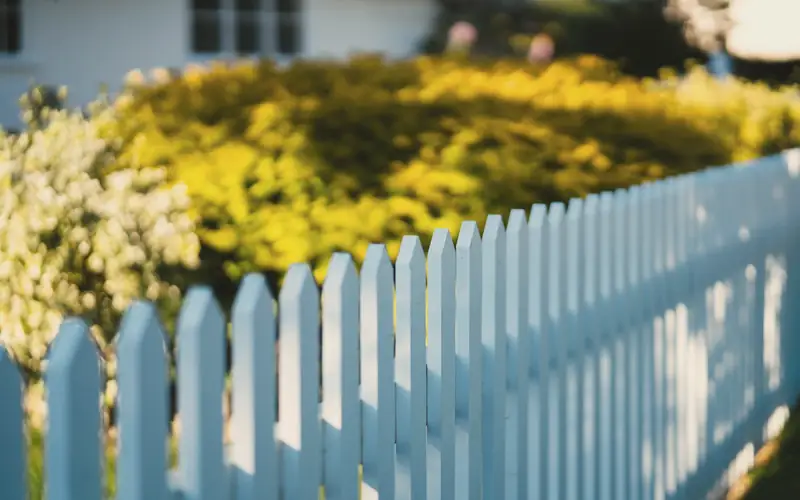 Wit hekje voor een bloeiende tuin