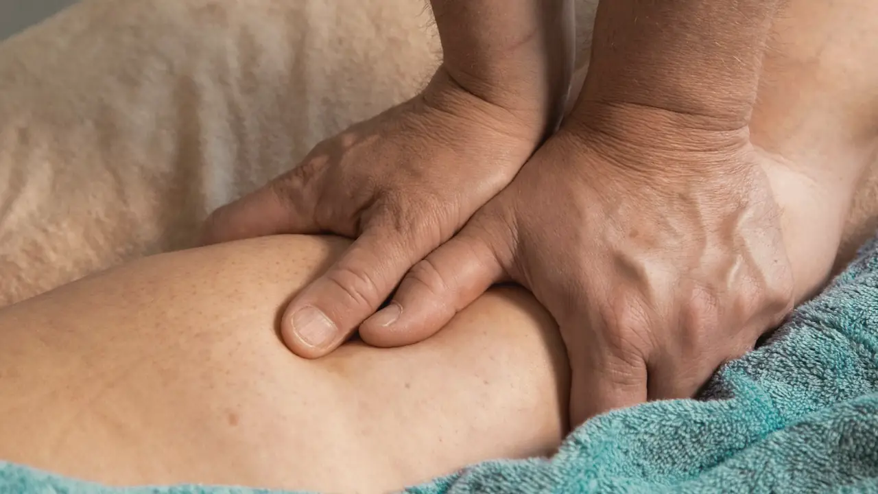 Handen die een schouder masseren