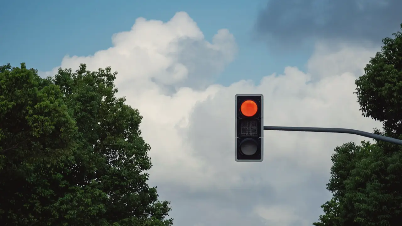 Verkeerslicht op rood tegen de lucht
