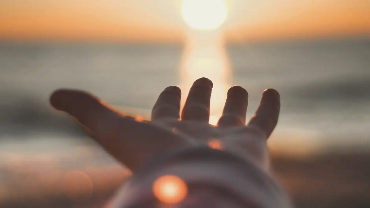 Hand die naar het licht reikt