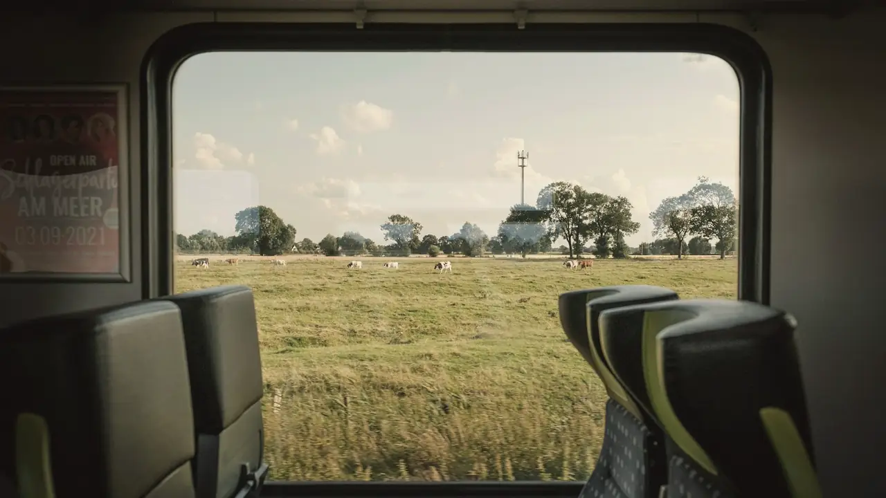 Uitzicht op weilanden vanuit een treinraam