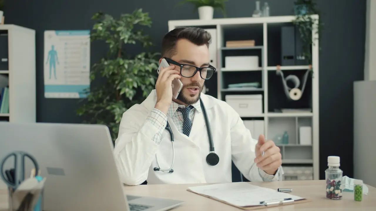 Huisarts aan de telefoon achter een bureau